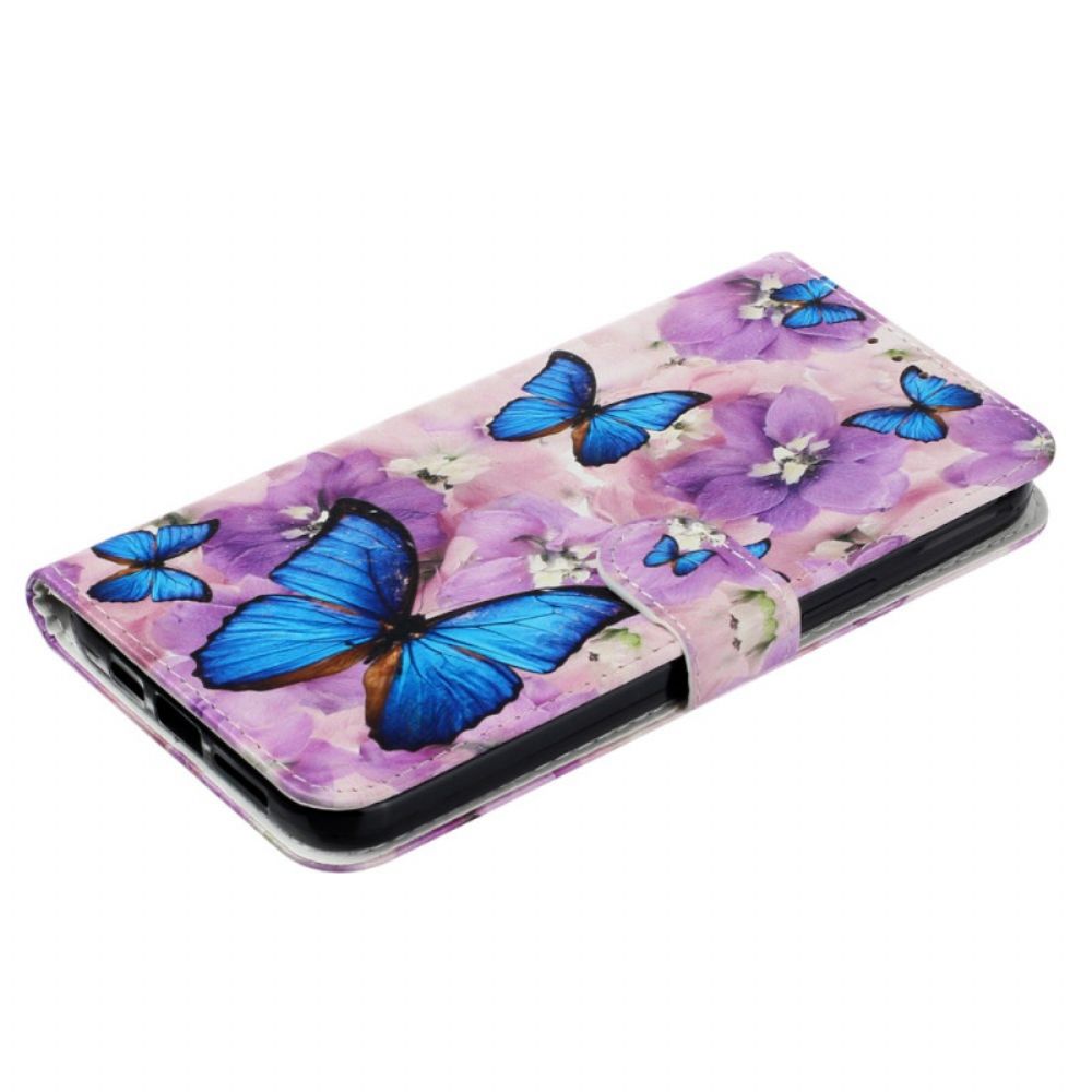 Folio-hoesje iPhone 16 Pro Telefoonhoesje Blauwe Vlinders En Paarse Bloemen Met Riempje